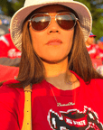 A life style product picture of Baseball Mom necklace. A model is wearing a Baseball Mom necklace at a baseball game