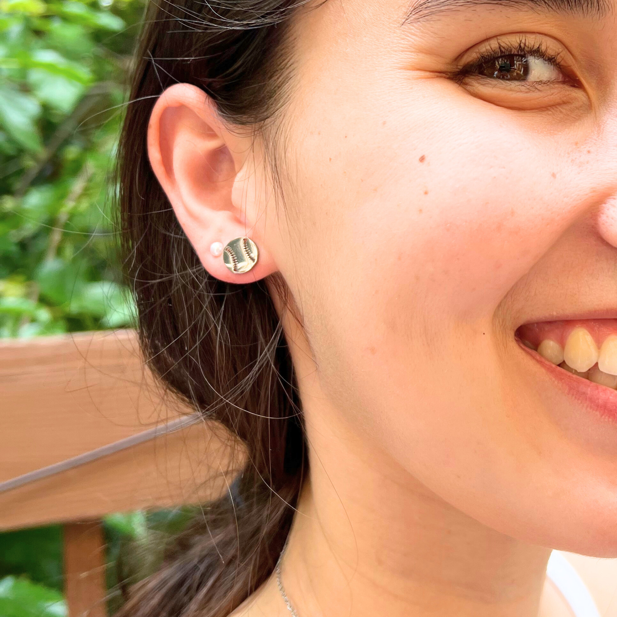 Lifestyle image of cute minimalist baseball stud earrings. Lifestyle image of softball stud earrings.