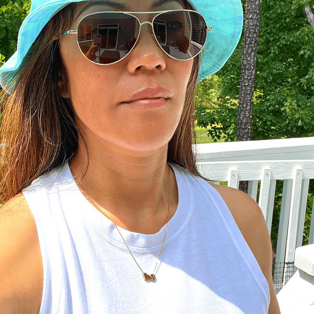 Product lifestyle picture for the Heart and Baseball charm necklace in gold  with white shirt