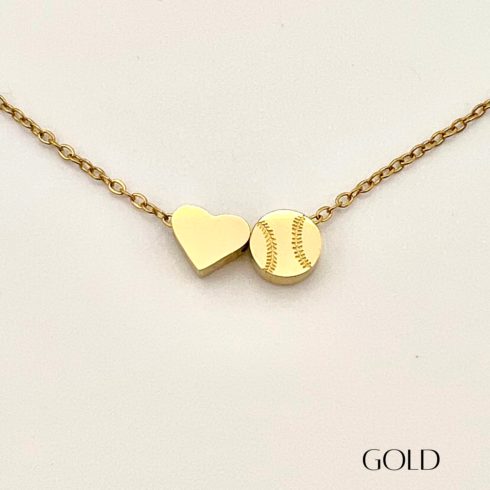 Product close up picture for the Heart and Baseball charm necklace in gold